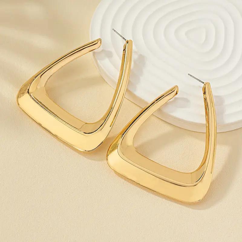 Geometric triangle hoop earrings on ear | Hair Your Lux