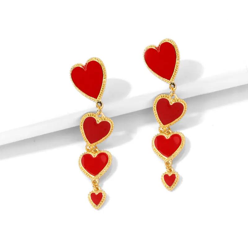 Four red heart charm long drop earrings worn | Hair Your Lux